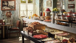 Een buffet met diverse gerechten, een schutterswiel decoratie en een rustieke muur met ingekaderde foto's.