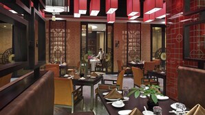 A restaurant interior with traditional decor, multiple dining tables, and red hanging lights. - Lake View Hotel (Beijing)