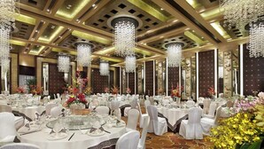 A banquet hall with round tables, white chairs, and chandeliers. - Lake View Hotel (Beijing)