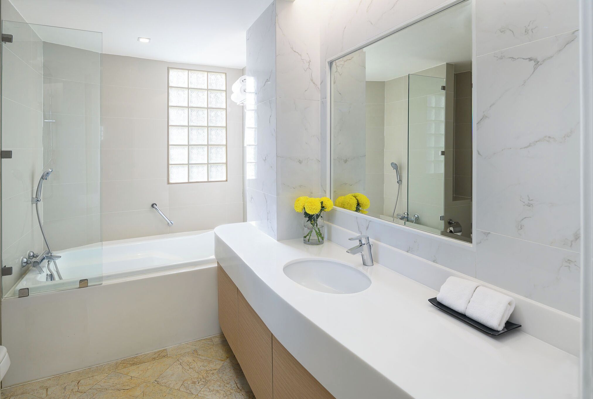 A modern bathroom with a large bathtub, a vanity with a sink, and a mirror.
