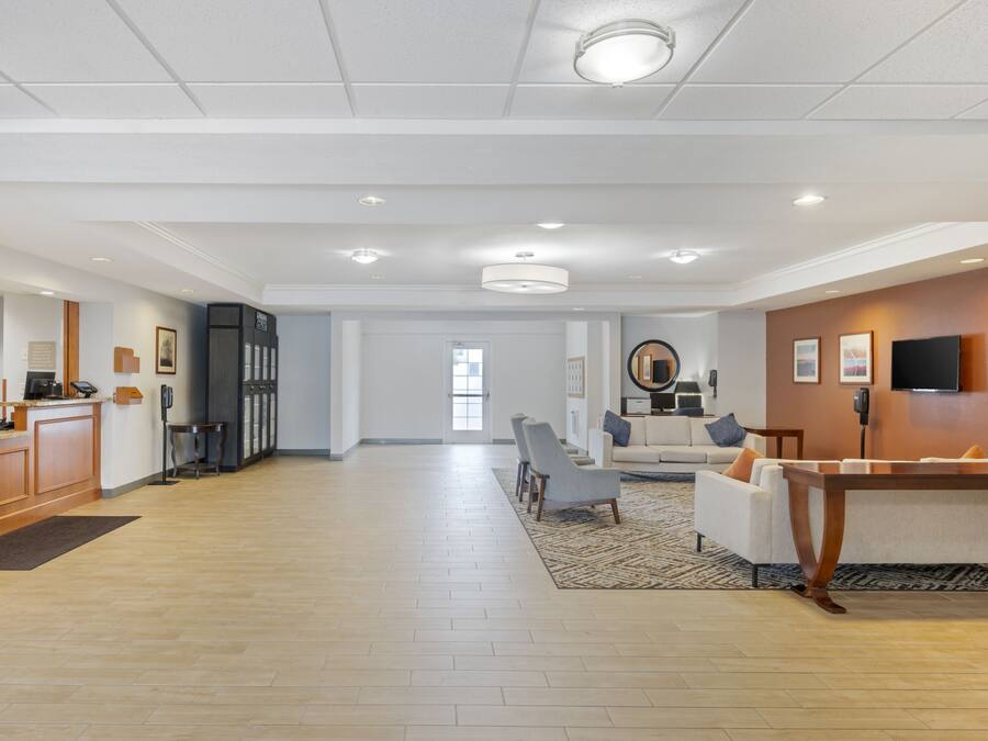 A spacious hotel lobby with a reception desk, seating area, and a dining table.