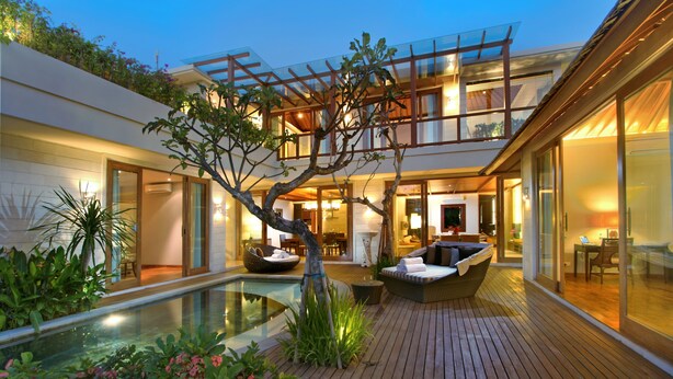 A modern house with a glass conservatory, a wooden deck, and a swimming pool. - The Akasha Seminyak Bali Luxury Villas (Seminyak)