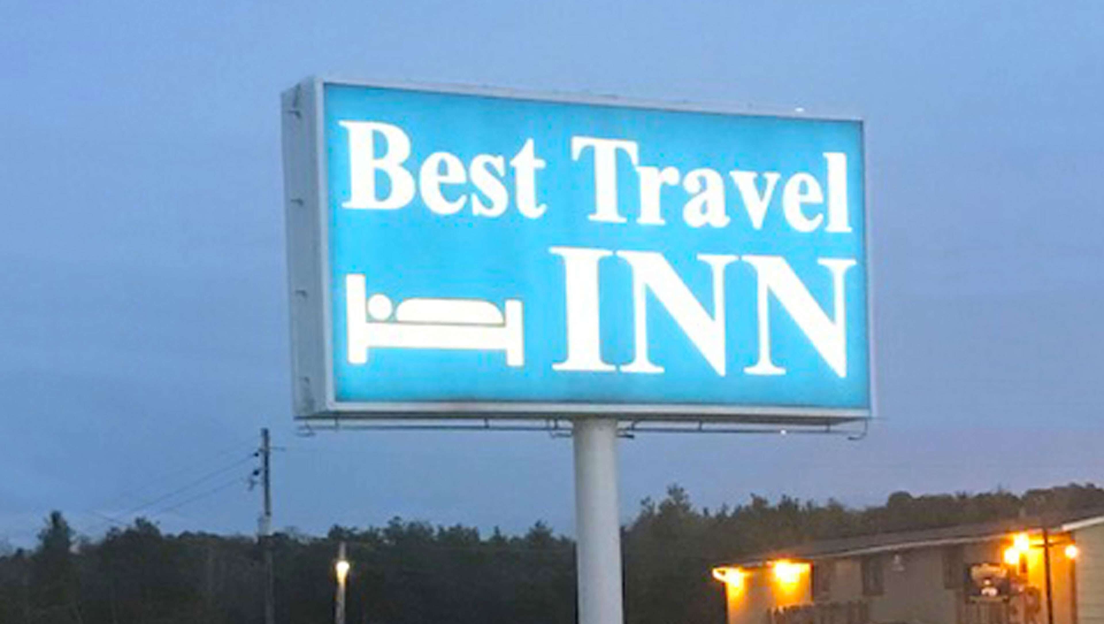 Une grande affiche publicitaire pour le Best Travel INN, avec un symbole représentant un lit.