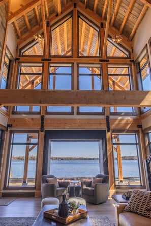 Un interior espacioso con techo alto, ventanas amplias y chimenea.
