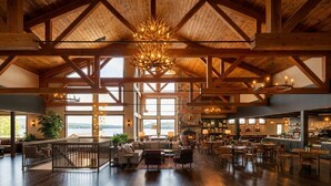 A spacious interior with high ceilings, wooden beams, and large windows offering views of the outdoors. - Cragun's Resort & Hotel (Brainerd)