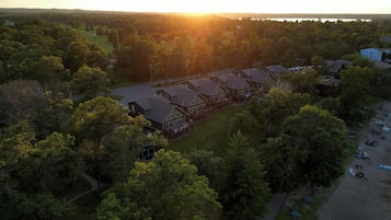 A large, multi-story building with a traditional architectural style, surrounded by dense trees and a golf course.