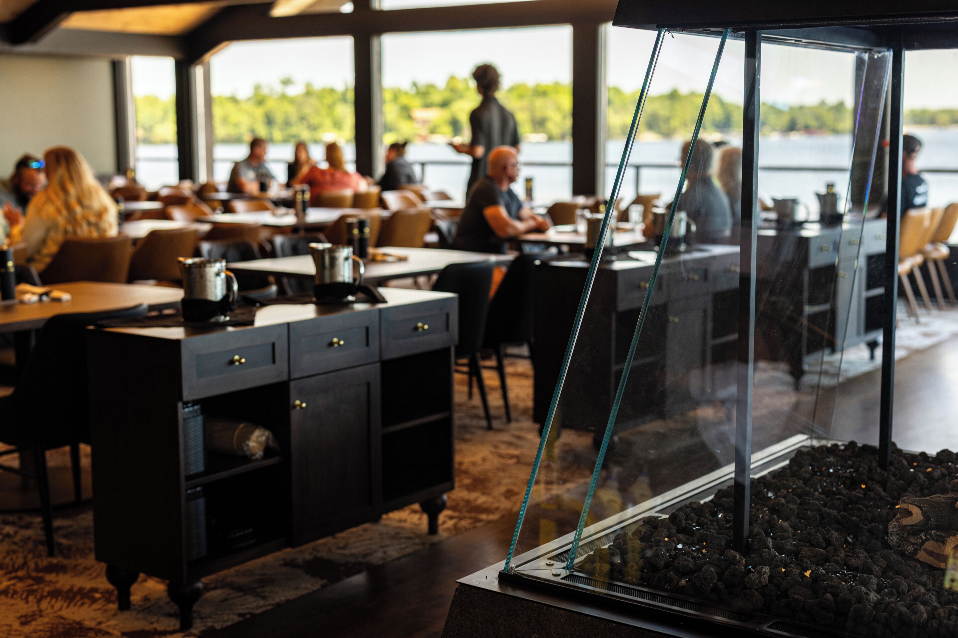 Un restaurant avec des tables et des chaises, un appareil à café et une vue sur l’extérieur.