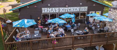 A restaurant with outdoor seating and a sign that reads 'IRMA'S KITCHEN OPEN TO PUBLIC.'