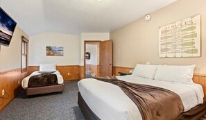 A hotel room with a large bed, a smaller bed, a television, a painting, and a wall with a list of lake rules. - Cragun's Resort & Hotel (Brainerd)