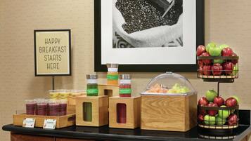 Un buffet de petit-déjeuner proposant une variété de fruits et des distributeurs de jus.