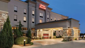 A Hampton Inn & Suites hotel with a modern facade, stone accents, and a well-lit entrance. - Hampton Inn & Suites Enid (Enid)