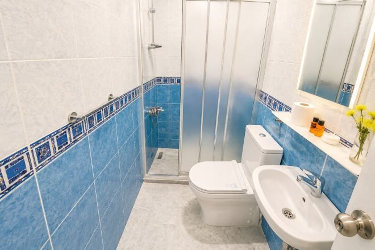 A bathroom with a toilet, sink, and shower.