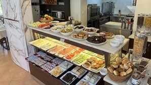 A buffet with various food items and condiments. - Anadolu Hotel (Istanbul)