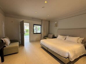 Una habitación de hotel con una cama, un escritorio, una silla, una ventana y una puerta.