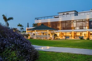 Un edificio moderno con techo plano, ventanas grandes y un espacio exterior cubierto.