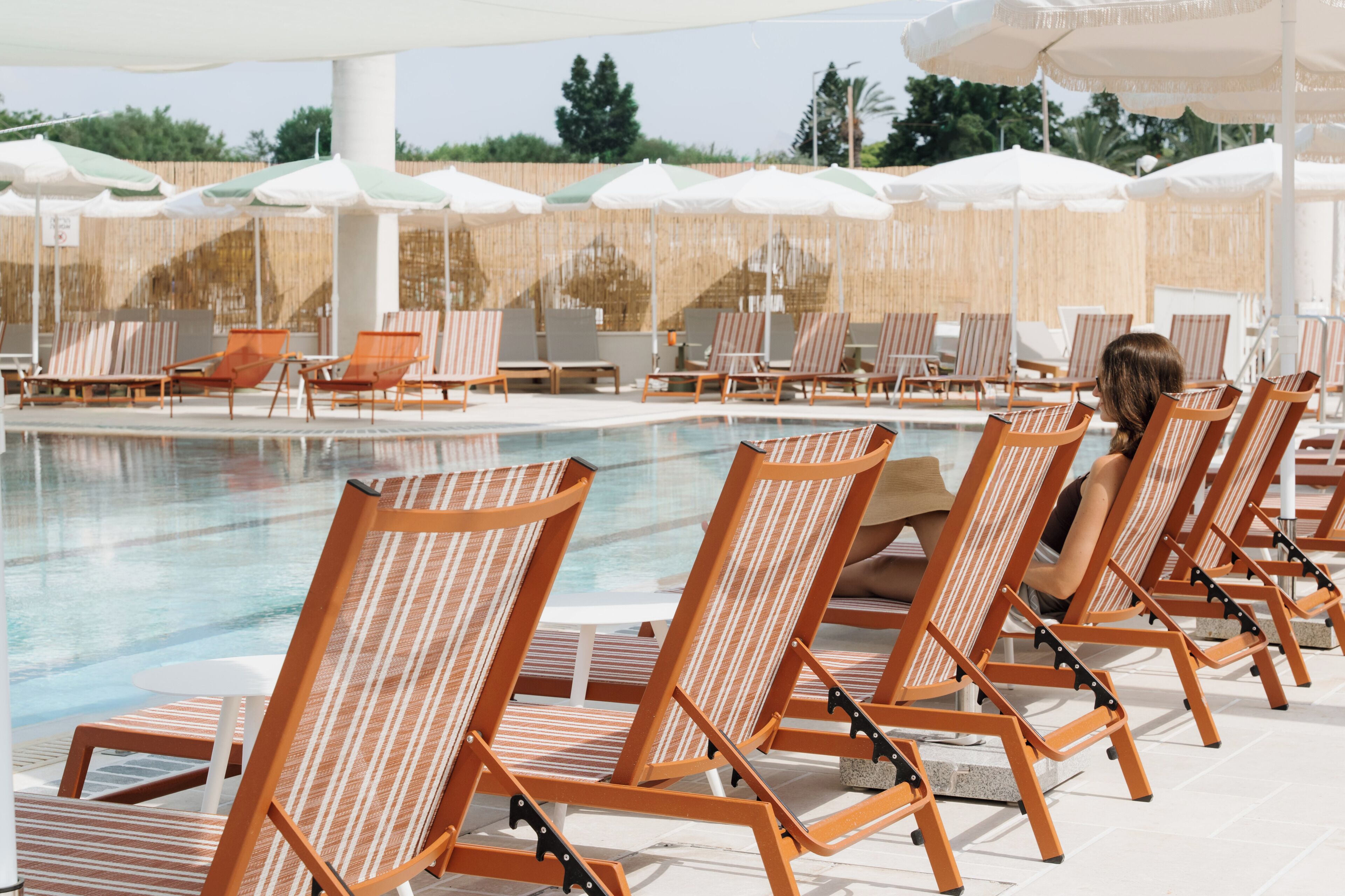 A poolside area with lounge chairs and umbrellas.
