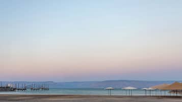 A beach with umbrellas and a clear sky.