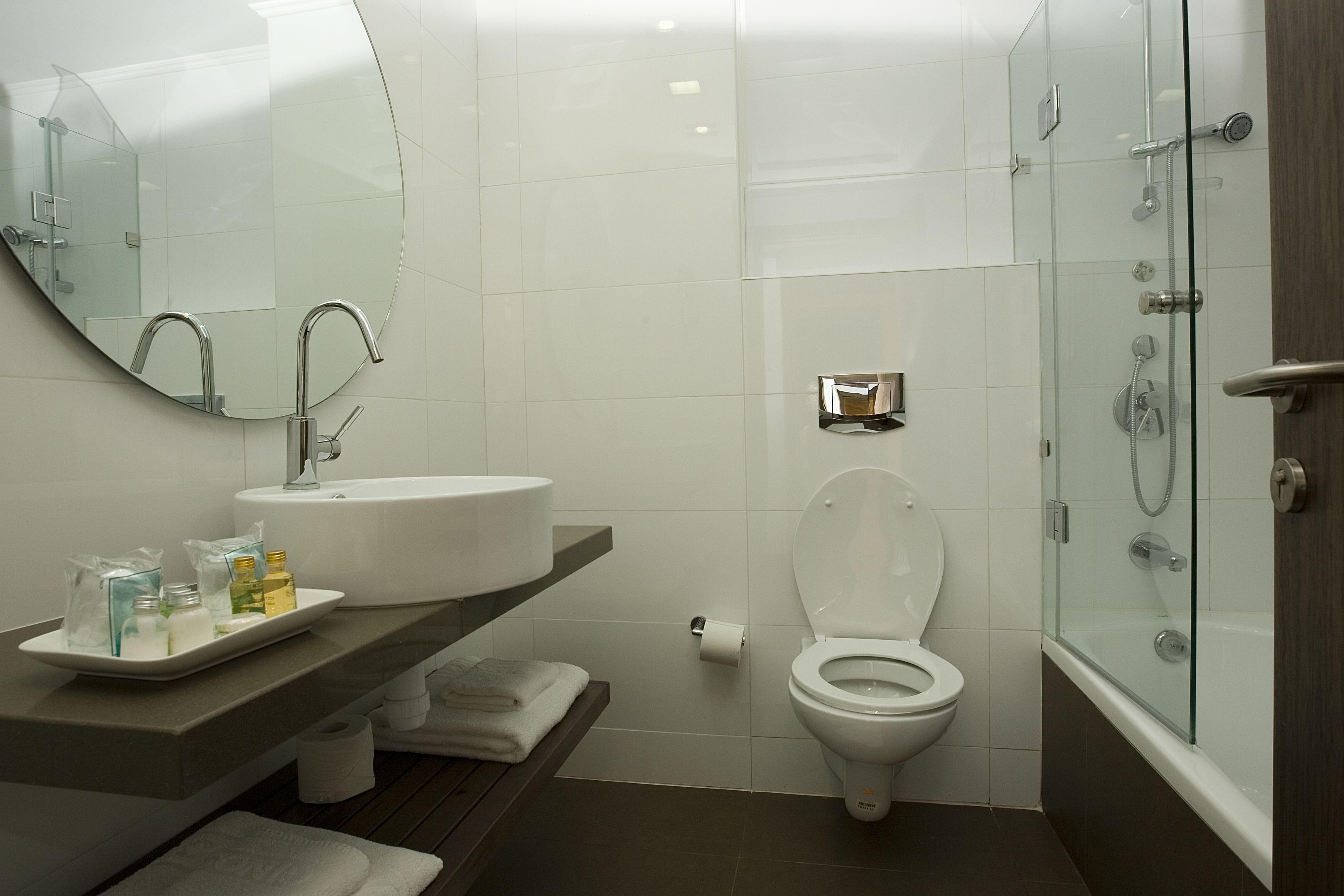 Uma casa de banho moderna com lavatório branco, sanita e cabine de duche com vidro.