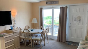 A room with a television, a desk, a chair, a table, and a bed. - Roman Holiday Motel (North Wildwood)