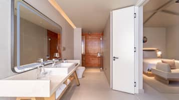 Un baño moderno con lavamanos dobles, un espejo grande y una zona de ducha.