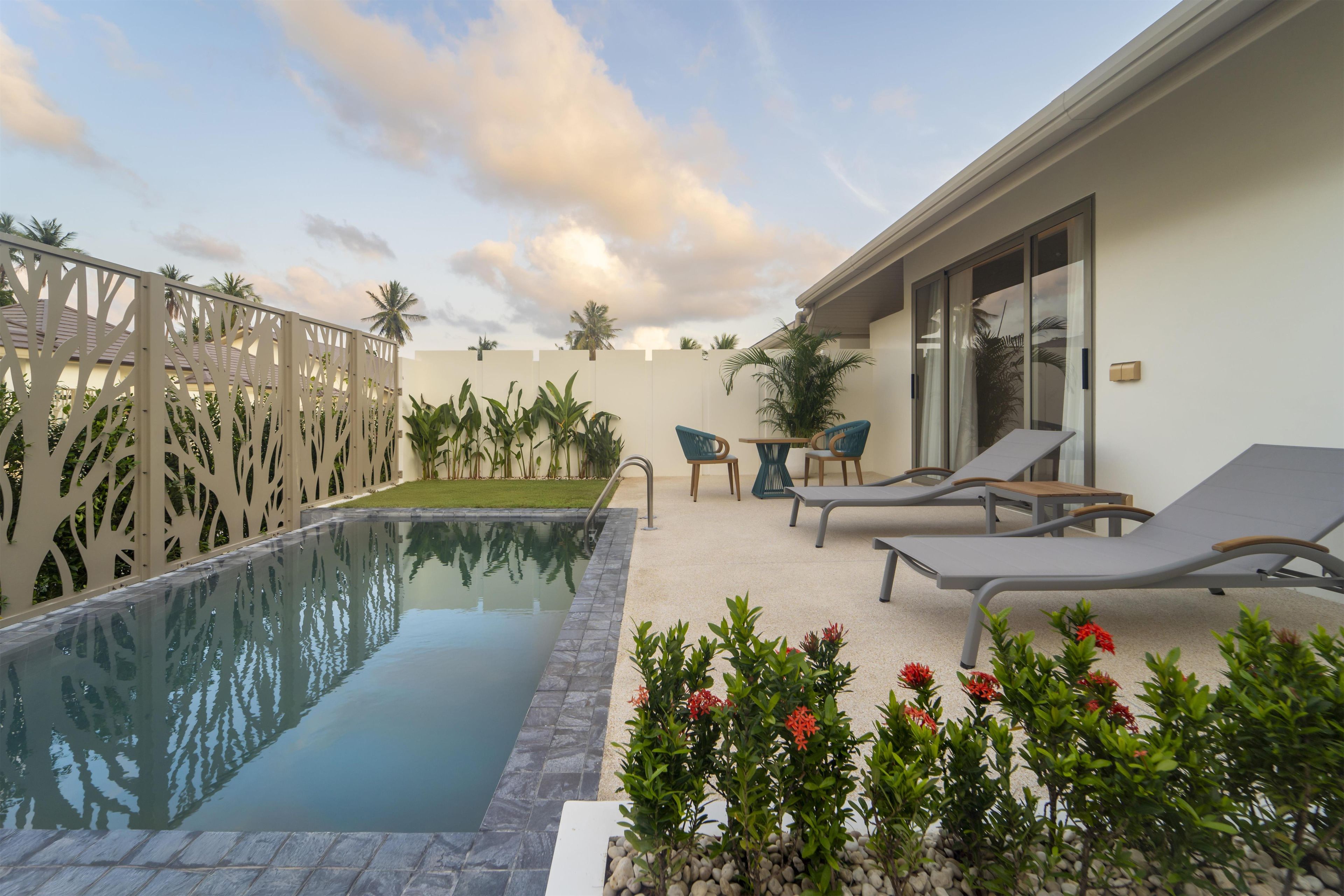 A swimming pool with lounge chairs and a decorative fence.