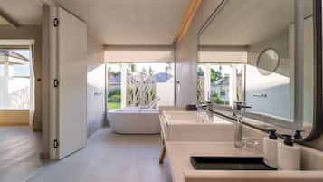 A modern bathroom with a bathtub, a large mirror, and a sink with a countertop.