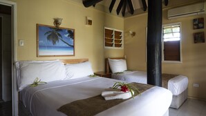 A hotel room with two beds, a painting of a palm tree, and a window with blinds. - Daku Resort (Savusavu)