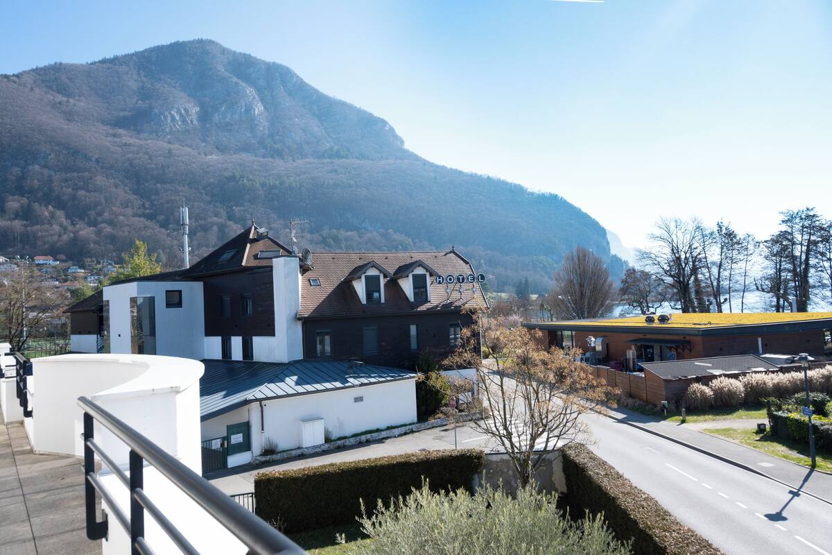 A hotel with a modern design, a mountain backdrop, and a clear view of the surrounding area.