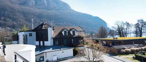 A hotel with a modern design, a mountain backdrop, and a clear view of the surrounding area.