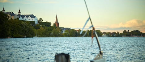 Vista desde un barco con una iglesia y un edificio blanco en la orilla.