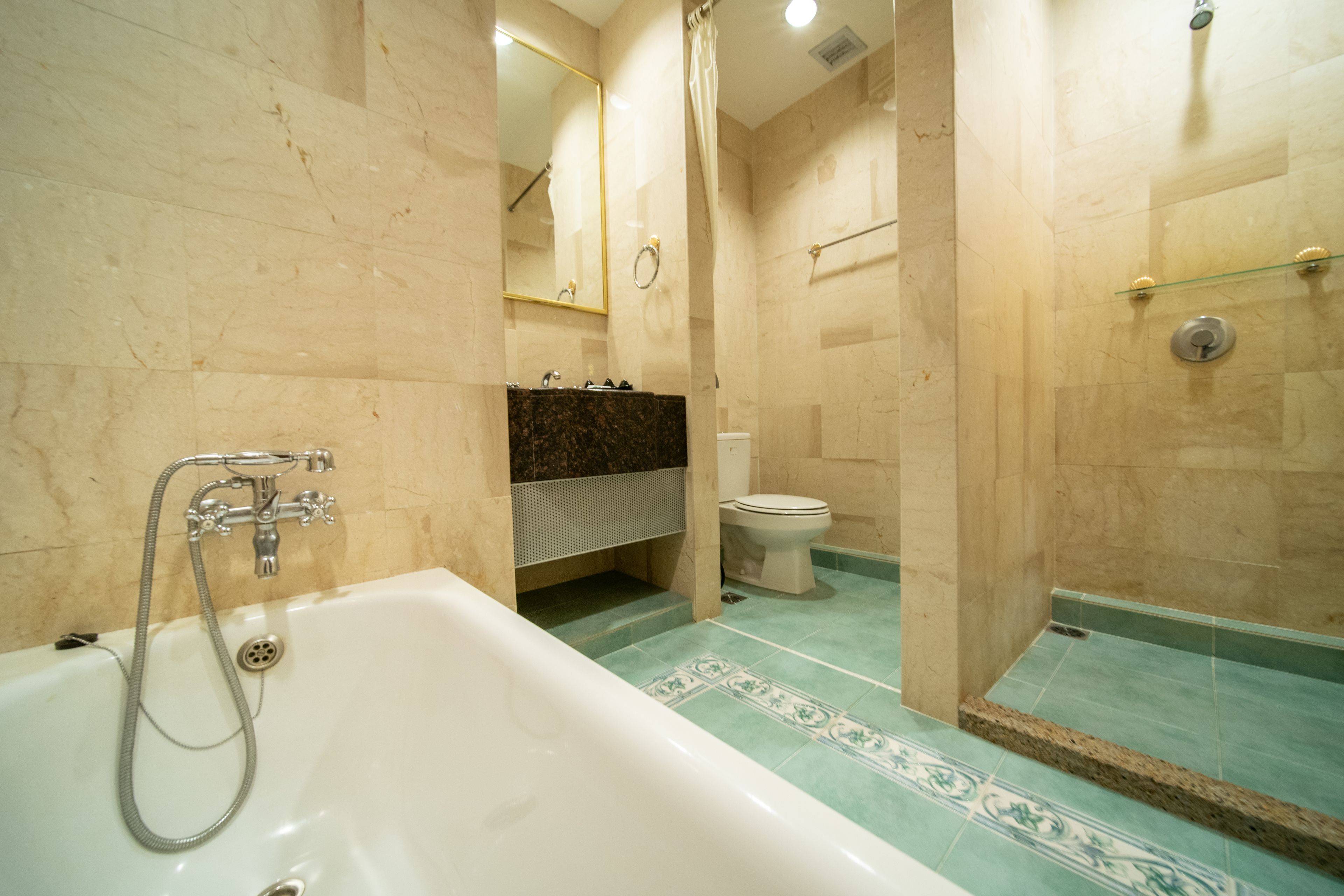 A bathroom with a bathtub, toilet, and shower area.