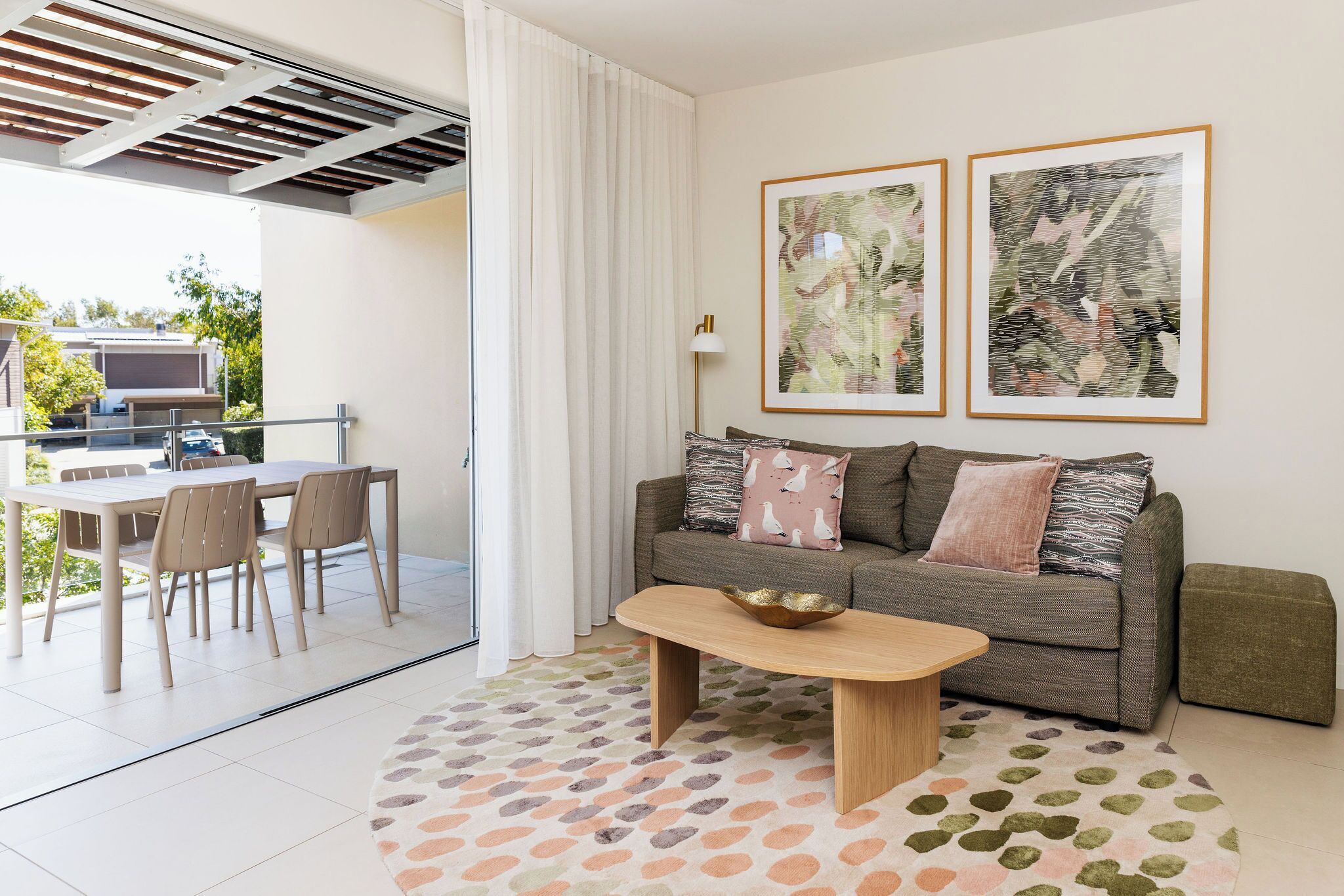 A modern living room with a sofa, coffee table, and dining area.