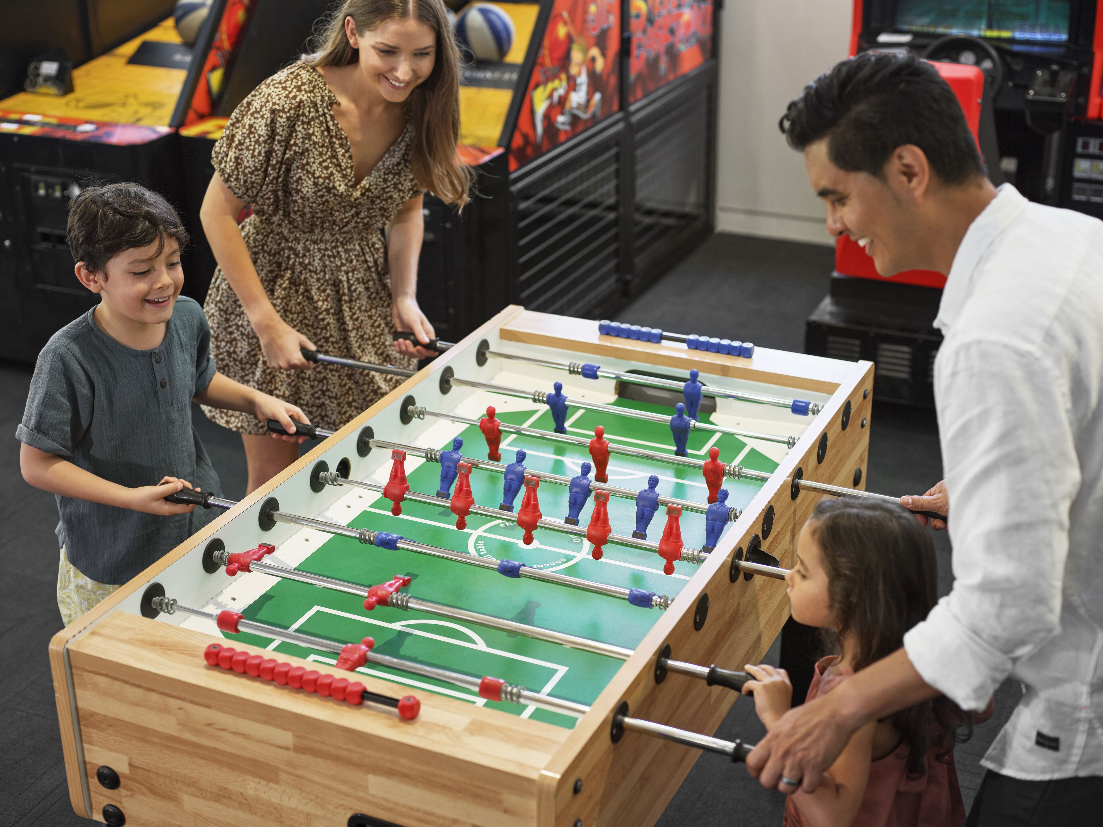 A group of people playing foosball.