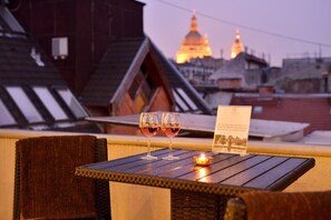 A table with two glasses of red wine, a candle, and a sign.