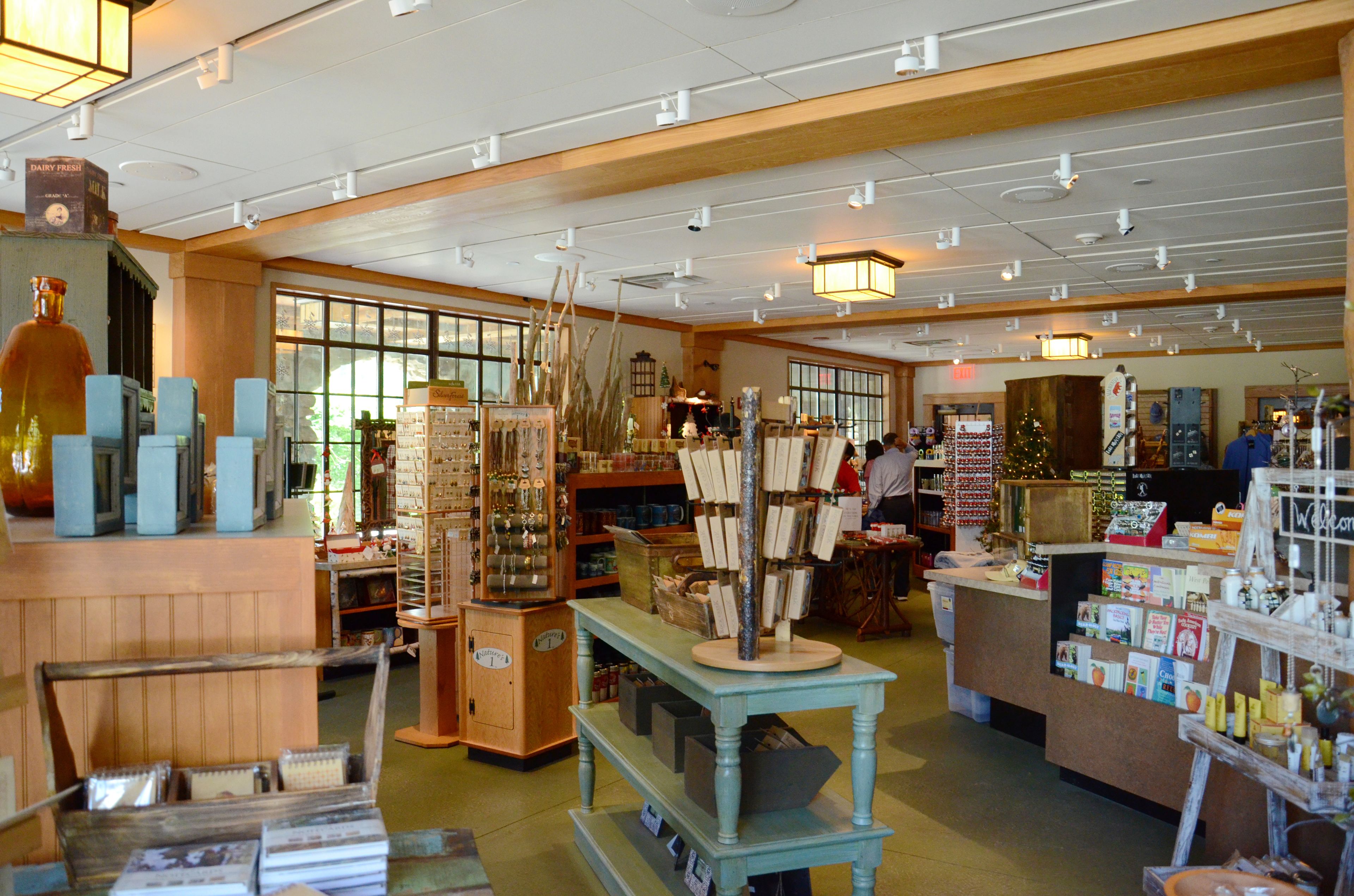 Una librería con estanterías de madera, una mesa central y un árbol de Navidad.