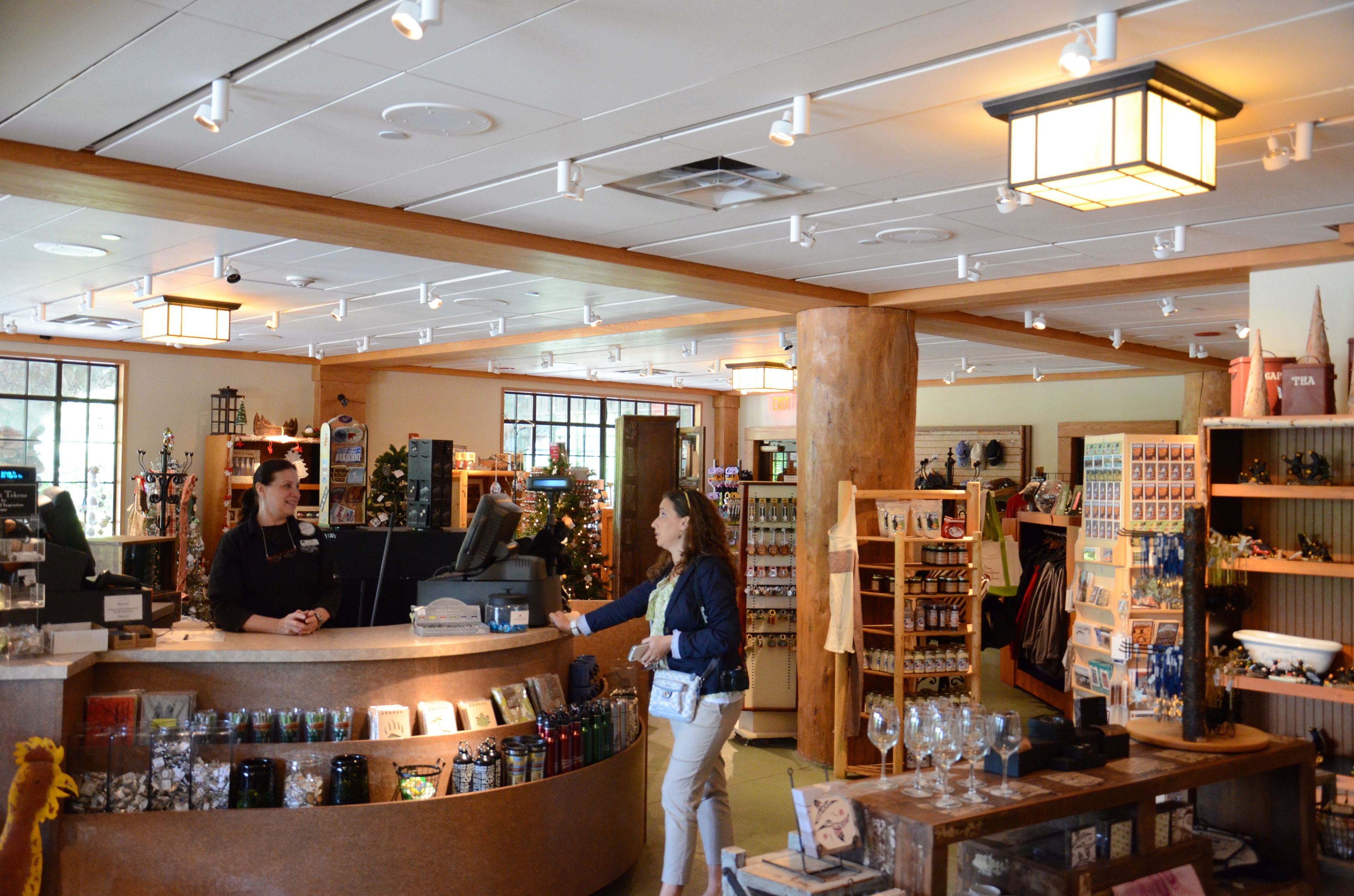A store interior with a cashier counter, shelves stocked with various items, and a Christmas tree.