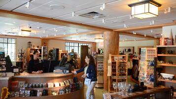 A store interior with a cashier counter, shelves stocked with various items, and a Christmas tree.