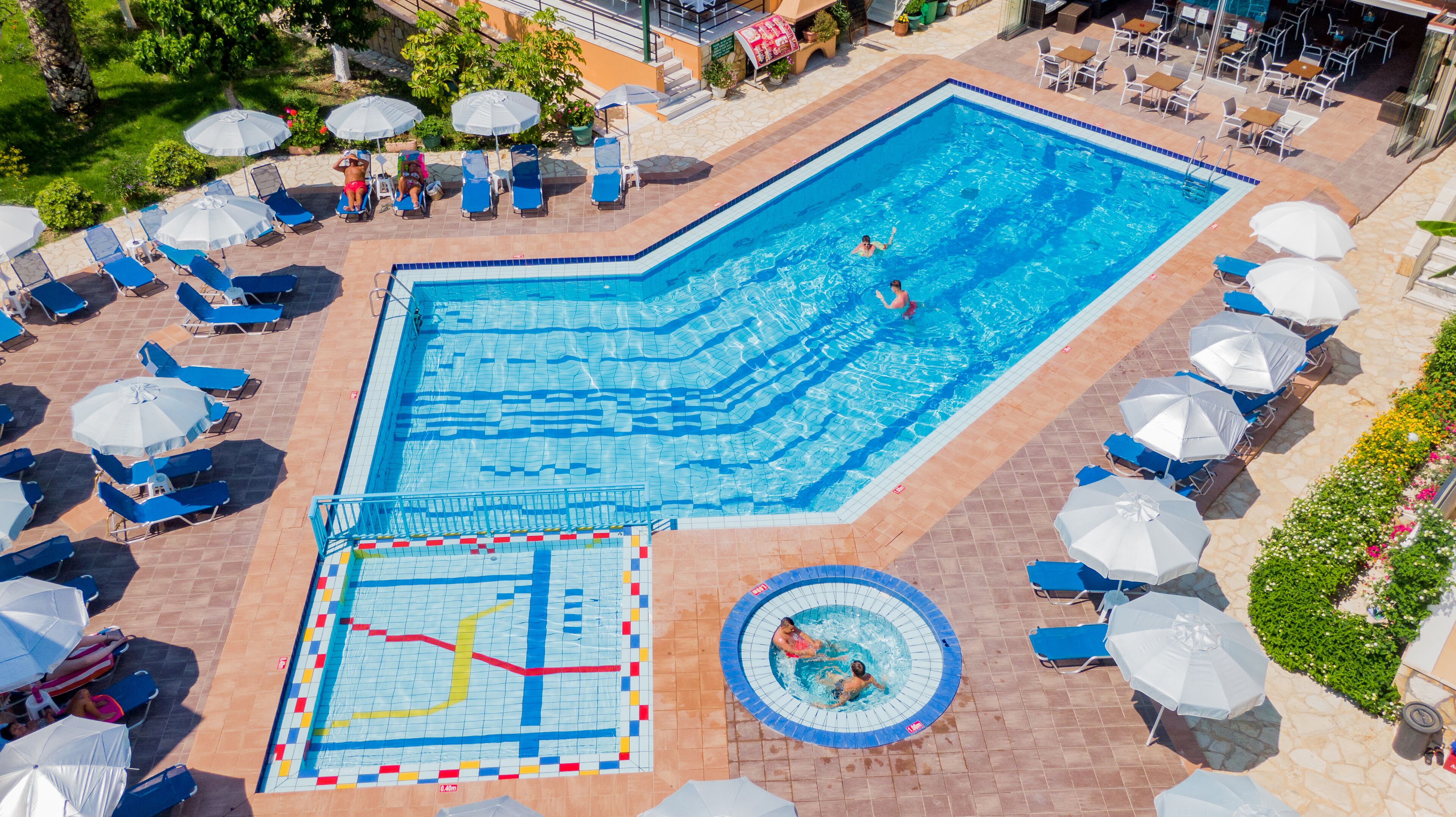 Una piscina al aire libre, sombrillas, sillones reclinables de piscina