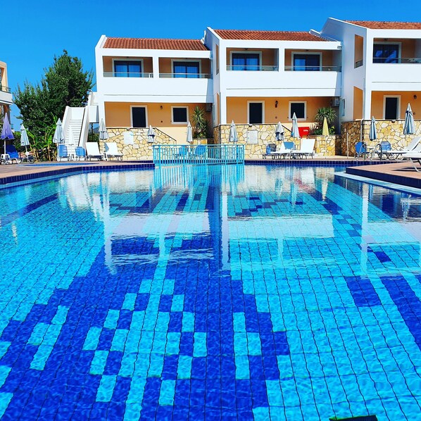 Piscine extérieure, parasols de plage, chaises longues