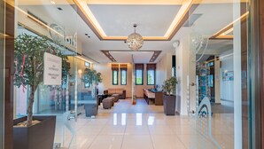 A hotel lobby with a modern design, featuring a reception desk, seating area, and large windows. - Oscar Hotel (Zakynthos)