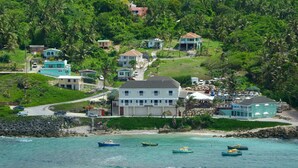 A coastal area with houses, a beach, and boats. - Atlantis Historic Inn (Bathsheba)