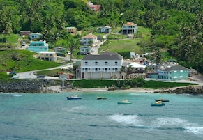 Una zona costera con casas, una playa y barcos.