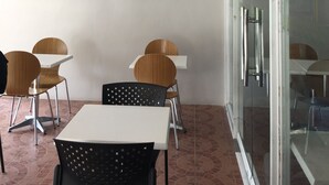 A cafe interior with a wooden sign reading "Cafe Campagueta," two tables, and four chairs. - Sampaguita Suites Plaza Garcia (Cebu City)