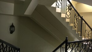 A staircase with geometric railings and a light fixture on the wall. - Sampaguita Suites Plaza Garcia (Cebu City)