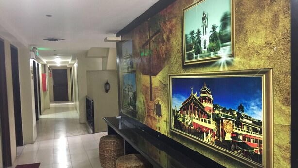 A hallway with a reception desk, a television mounted on the wall, and a door at the end. - Sampaguita Suites Plaza Garcia (Cebu City)