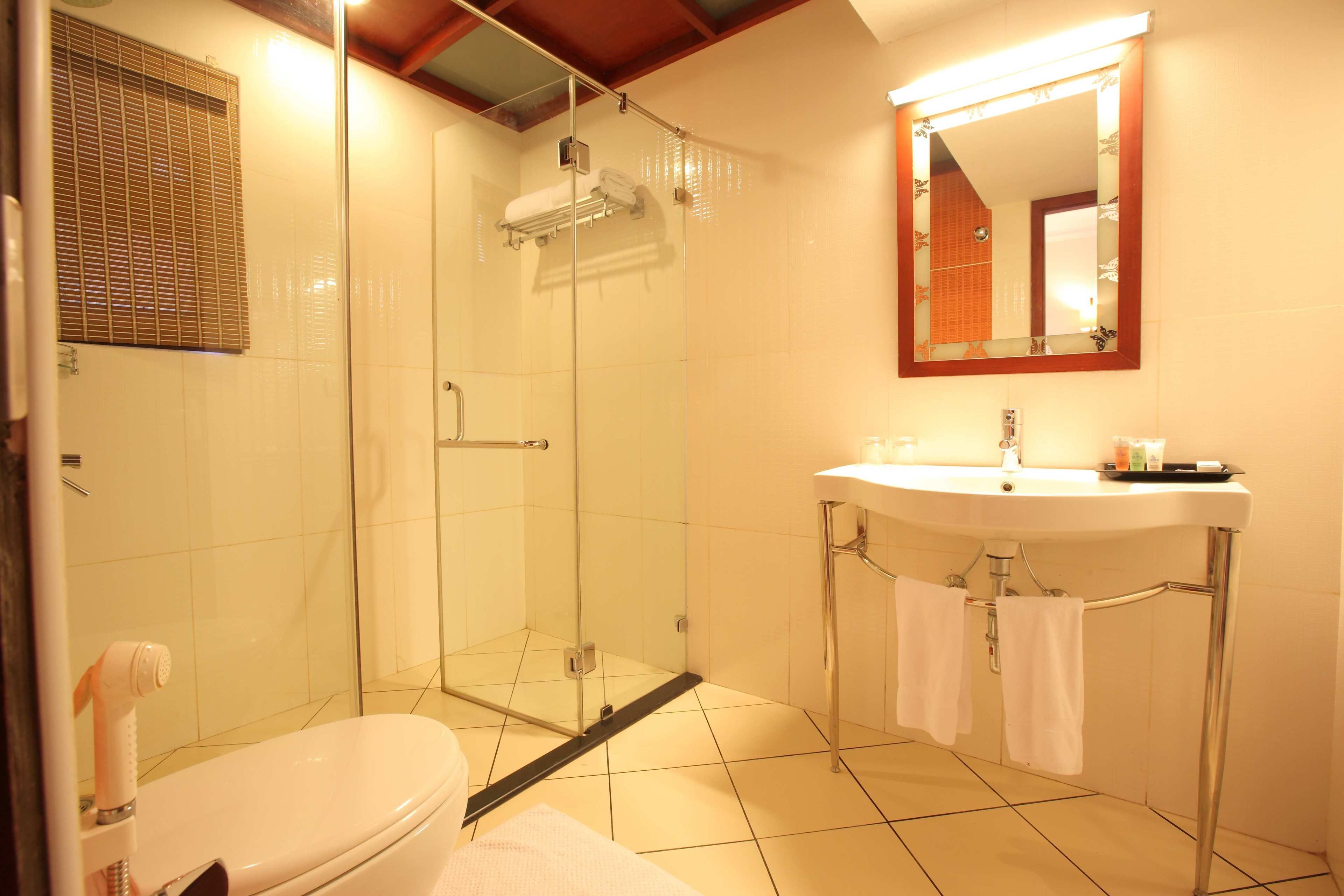 A bathroom with a glass-enclosed shower, a white sink, and a mirror above the sink.
