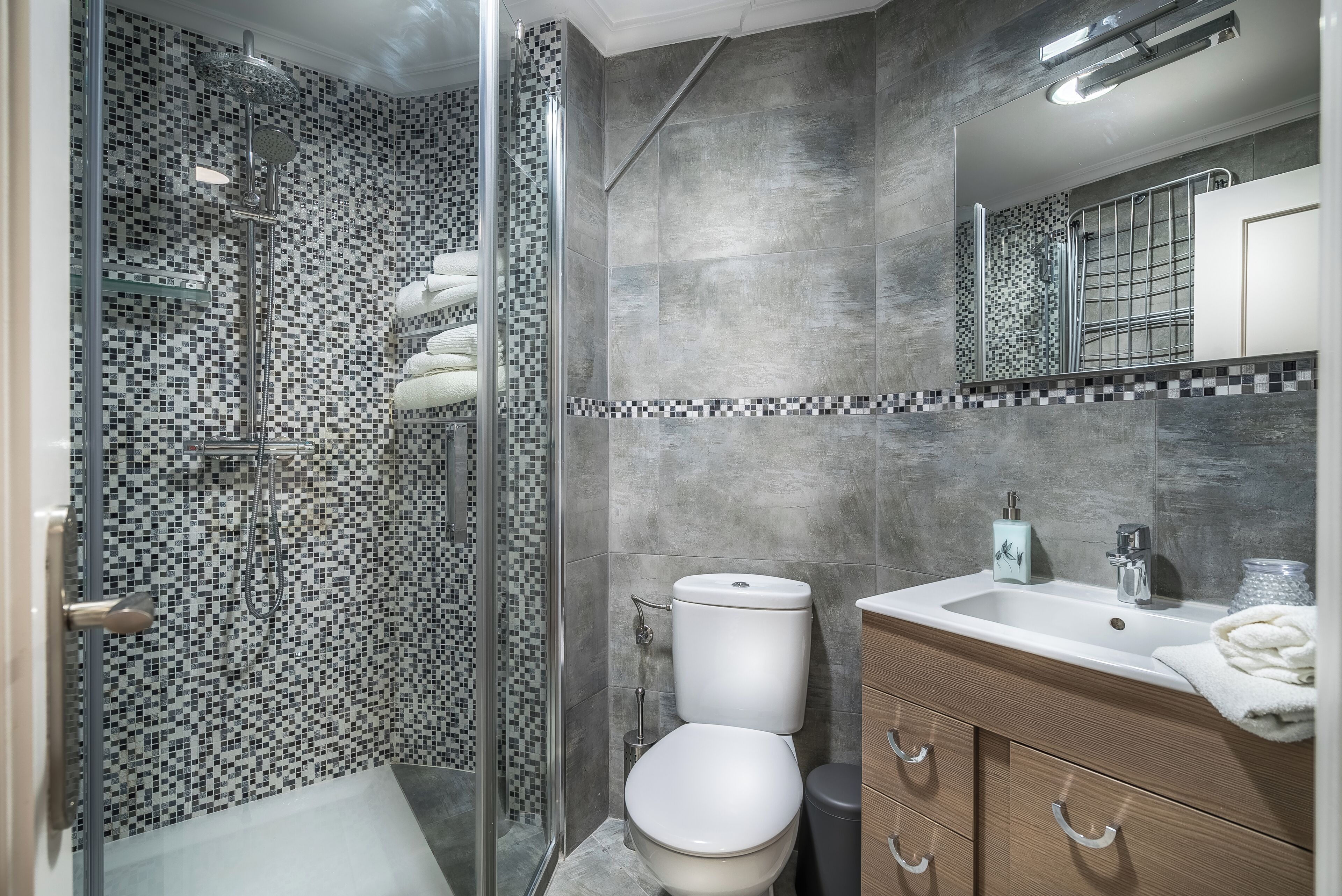 A modern bathroom with a shower, toilet, and vanity.