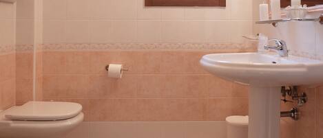 Un baño con inodoro, bidé y lavabo.