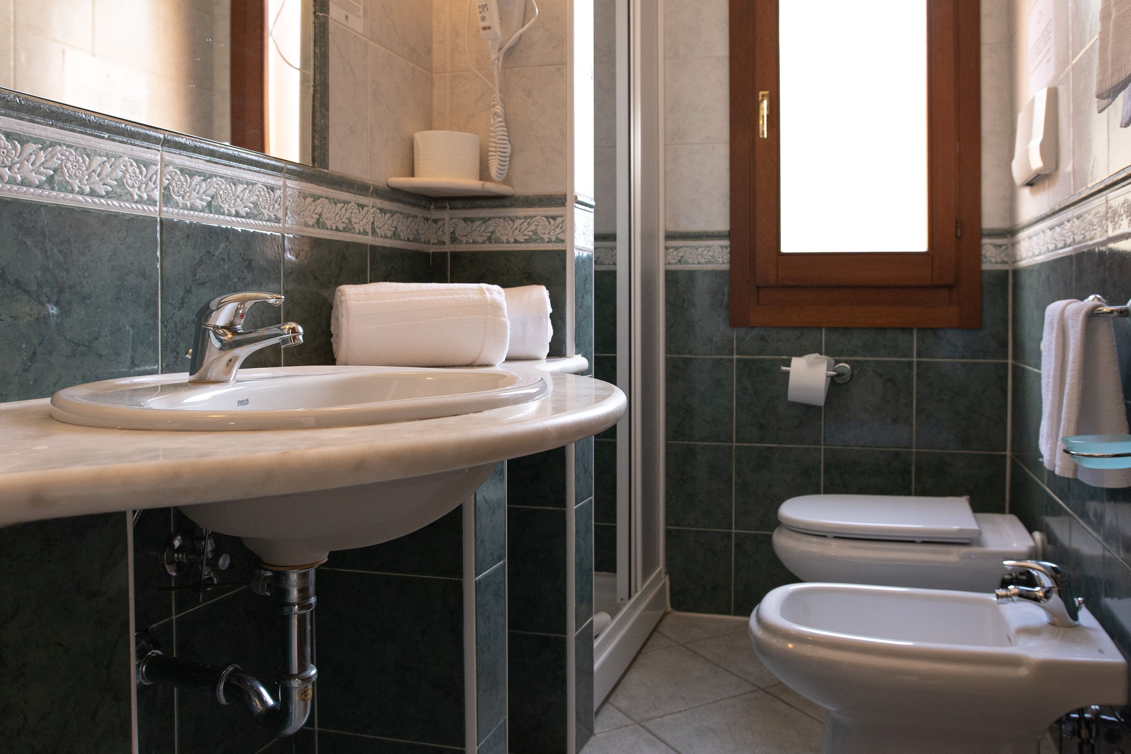 A bathroom with a sink, bidet, and toilet.