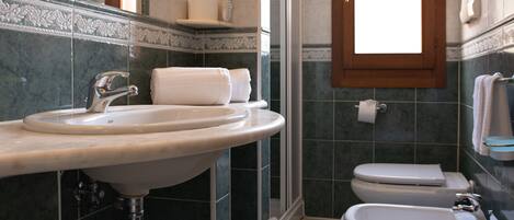 A bathroom with a sink, bidet, and toilet.